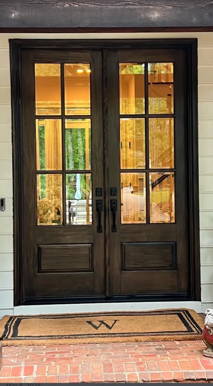 Dark wood double entry doors with divided glass and black hardware