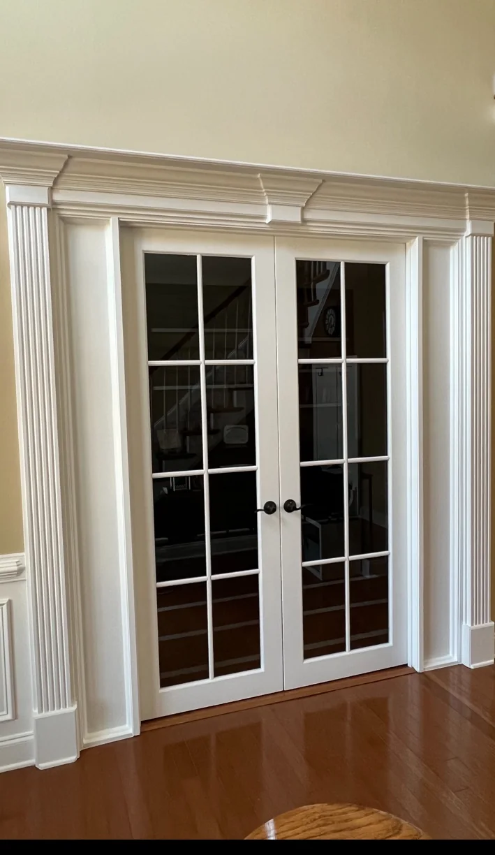 White interior French double doors with divided glass panes and decorative trim