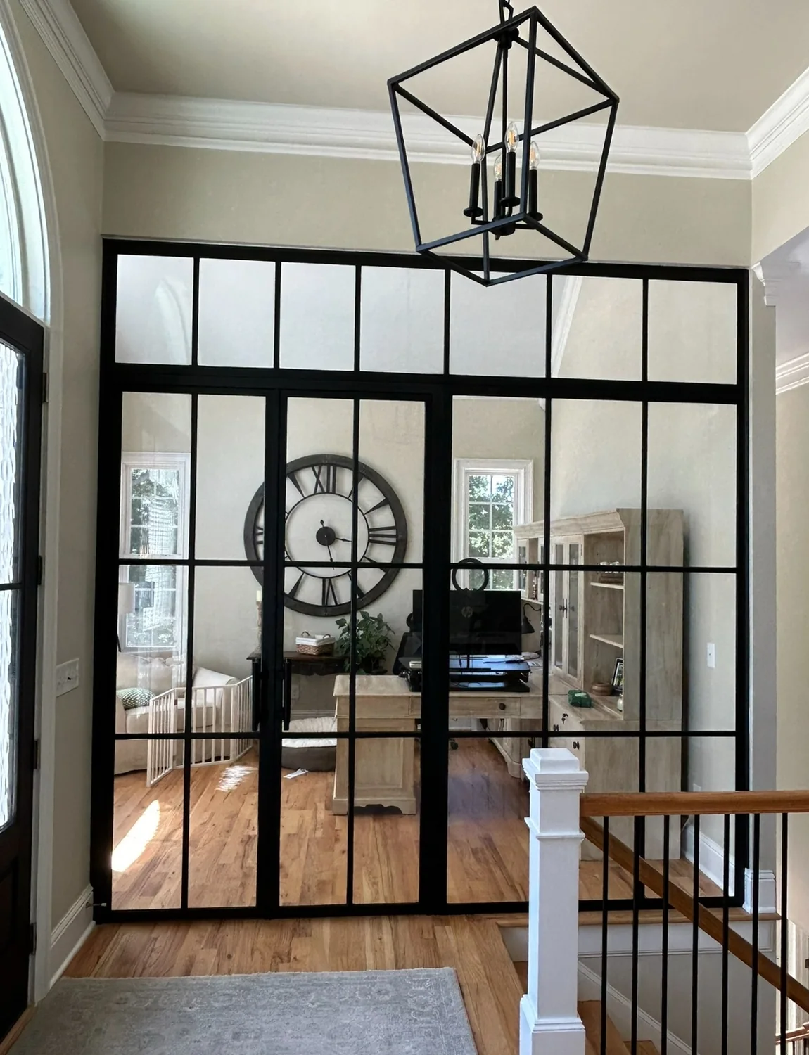 Black grid-style interior glass door partition with transom panels