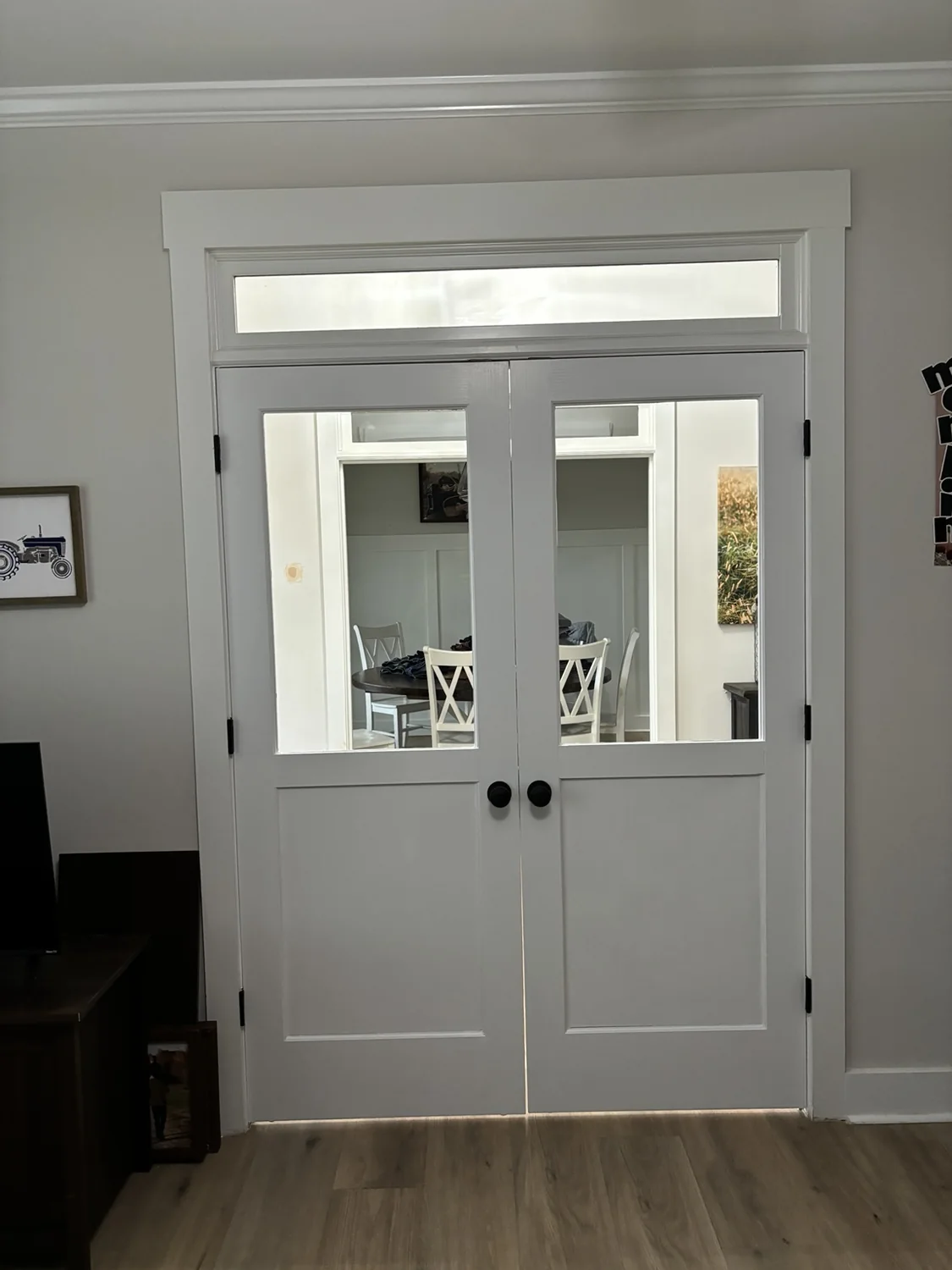 White interior double doors with glass upper panels and a transom window