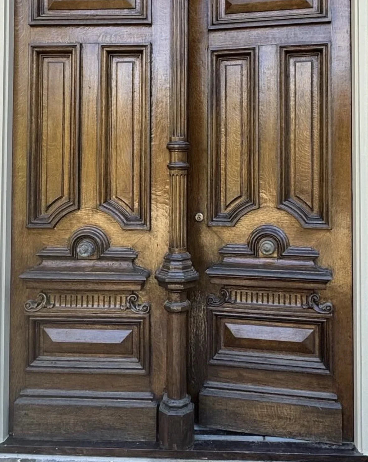 Ornate carved wood double doors before refinishing with a weathered existing finish