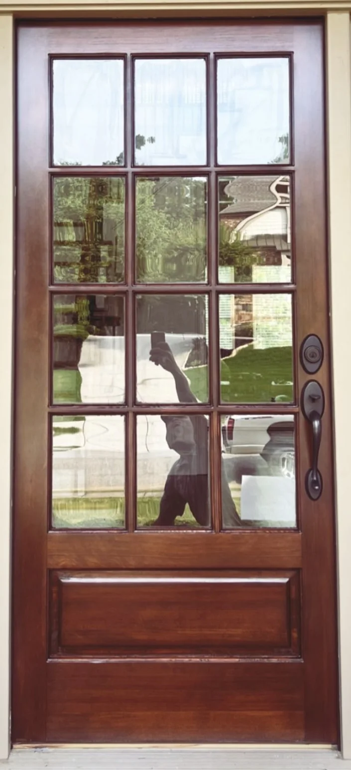 Wood and glass entry door after refinishing with a deeper polished finish