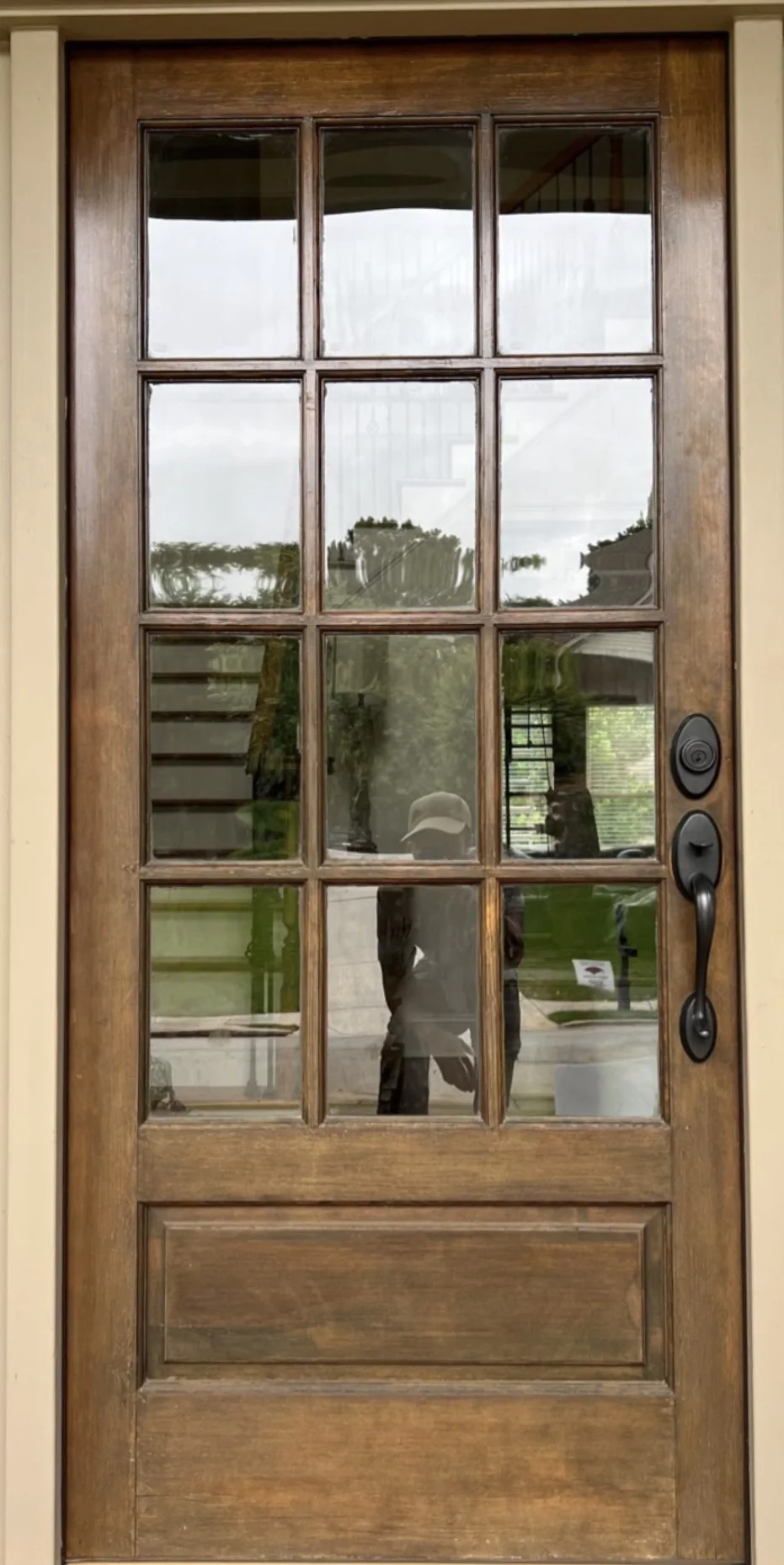 Wood and glass entry door before refinishing with a faded uneven finish