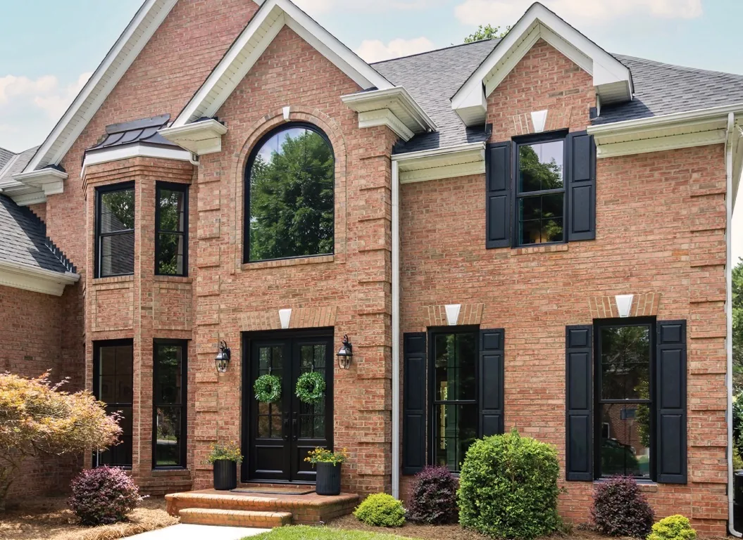 Brick home with black replacement windows and coordinated shutters